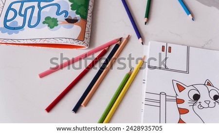 Coloring picture and pencils on table	