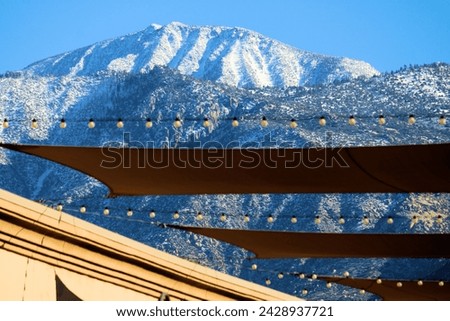 Awning and decorative lights on a patio with snow capped Mt San Jacinto beyond taken at a plaza in Cabazon, CA