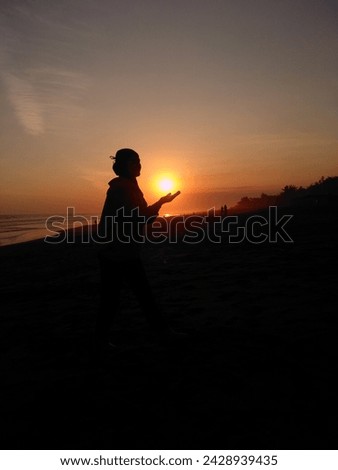 silhouette of a woman praying when sunset at beach, ramadhan kareem, silhouette photo, ramadhan mubarak, praying when sunset, adzan maghrib, eid mubarak Royalty-Free Stock Photo #2428939435
