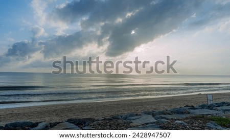 pictures of the sea On a day when the wind and waves are calm Suitable for relaxation The sky has golden light from the sun shining through the clouds and striking the water beautifully.