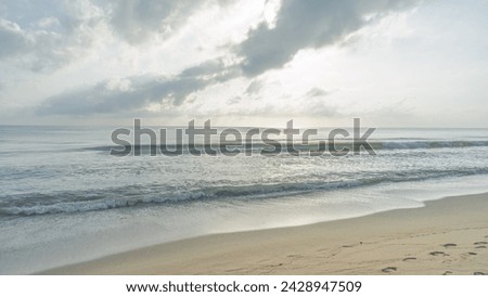 pictures of the sea On a day when the wind and waves are calm Suitable for relaxation The sky has golden light from the sun shining through the clouds and striking the water beautifully.