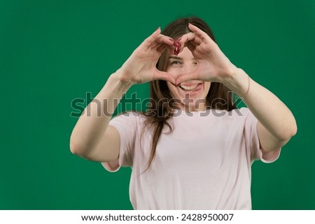 pretty young girl making a heart symbol with her hands, focus on the hands. High quality photo