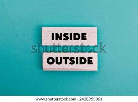 A colouted wooden block with word “ INSIDE, OUTSIDE” on it