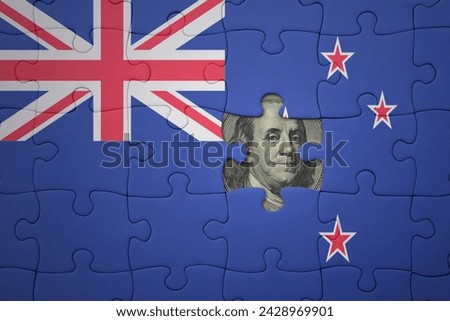 puzzle with the colourful national flag of new zealand and usa dollar banknote. finance concept