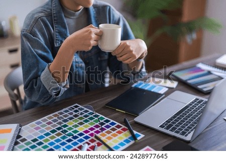Graphic designer women drink coffee and read data on laptop to thinking logo brand graphic design.