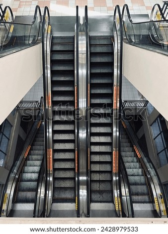 Capture the solitude of urban infrastructure with empty escalators, their sleek design casting dramatic shadows in dim light.