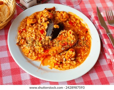 Appetizing racy seafood paella with mussels and prawns.Traditional Valencian cuisine Royalty-Free Stock Photo #2428987593