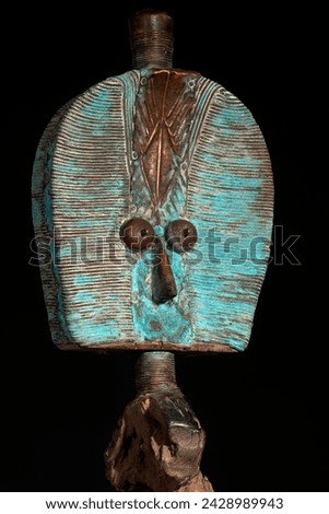 Kota reliquary figure from Gabon, isolated on a black background. Tribal African art, showcasing masterful craftsmanship and spiritual symbolism. Royalty-Free Stock Photo #2428989943