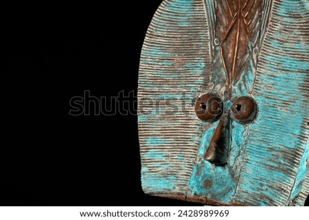 Close up of a wooden Kota reliquary figure from Gabon, isolated on a black background. Tribal African art, showcasing masterful craftsmanship and spiritual symbolism. Royalty-Free Stock Photo #2428989969