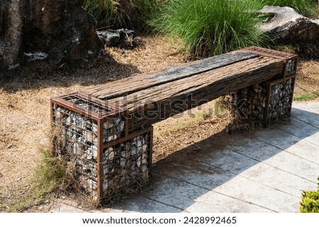 A wooden bench, piece of wood, or railway sleeper with legs made from stones. Royalty-Free Stock Photo #2428992465