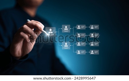 Organization chart, mind map. Businessman uses a pen to draw an organigram on a virtual screen. HR Manager works on HR company structure tree diagram, resource leveling, and career path concepts. Royalty-Free Stock Photo #2428995647