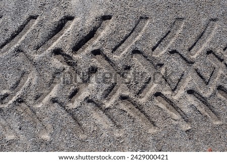 Close up textured background of tire tyre tracks imprinted in sand Royalty-Free Stock Photo #2429000421