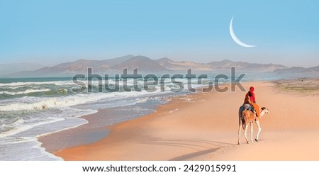 Sahara desert with Atlantic ocean meets with crescent moon - A woman in a red turban riding a camel across the thin sand dunes of the in Western Sahara Desert, Morocco, Africa Royalty-Free Stock Photo #2429015991
