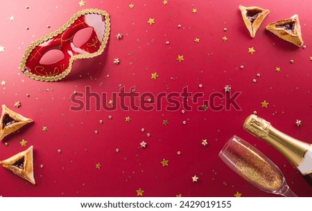 Happy Purim carnival decoration concept made from golden mask star and glitter on red background. (Happy Purim in Hebrew, jewish holiday celebrate)