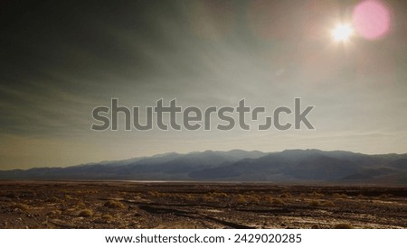 Relentless summer sun burns through smoke tendrils from distant California wildfires above ancient Lake Manly in Death Valley just days before it filled with water. Royalty-Free Stock Photo #2429020285