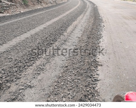 Close-up levelled Gravel base for road building construction work driveway with a small portion of bike front tyre ultra hd  stock image photo picture selective focus horizontal background top view 