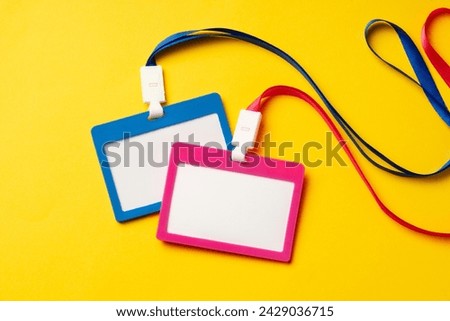 Colored blank nametags on strings on yellow background