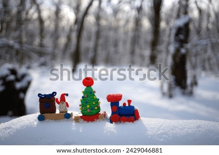 A toy train with a Christmas tree and plasticine gifts.