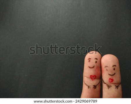 Love concept painted finger happy loving couple staying together smiley on black background valentine's day theme  ultra hd hi-res jpg stock image photo picture selective focus horizontal background.