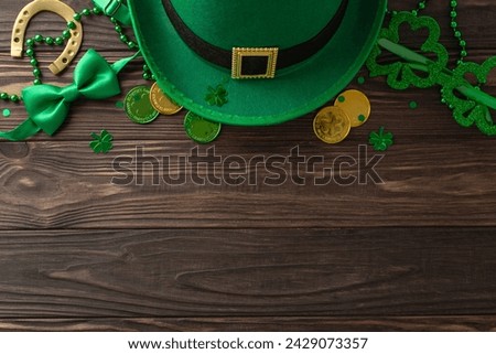 Enchanting St. Patrick's day top view composition, displaying clovers, elf's cap, treasure coins, celebration spectacles, bow tie, horseshoe, strands arranged on wooden backdrop with space for wording