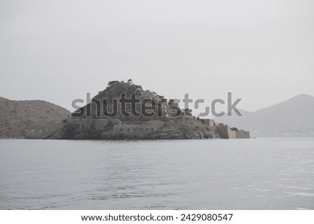 The abandoned Bastion Fortress and ruins of the famous historical landmark, Spinalonga, former Leper Colony on Kalydon, a rocky, arid Islet in the Bay of Elounda and wider area Mirabello Bay in Crete. Royalty-Free Stock Photo #2429080547