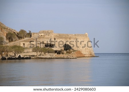 The abandoned Bastion Fortress and ruins of the famous historical landmark, Spinalonga, former Leper Colony on Kalydon, a rocky, arid Islet in the Bay of Elounda and wider area Mirabello Bay in Crete. Royalty-Free Stock Photo #2429080603