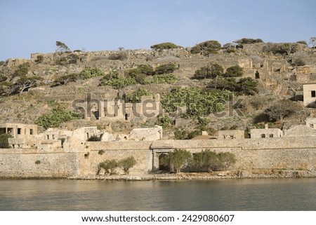 The abandoned Bastion Fortress and ruins of the famous historical landmark, Spinalonga, former Leper Colony on Kalydon, a rocky, arid Islet in the Bay of Elounda and wider area Mirabello Bay in Crete. Royalty-Free Stock Photo #2429080607