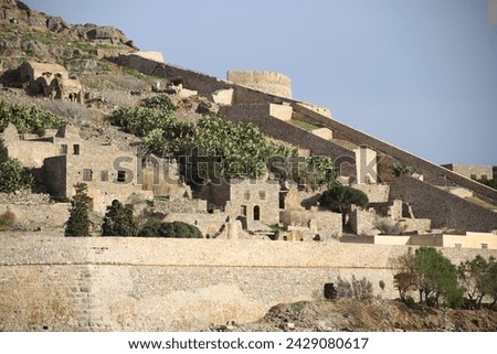 The abandoned Bastion Fortress and ruins of the famous historical landmark, Spinalonga, former Leper Colony on Kalydon, a rocky, arid Islet in the Bay of Elounda and wider area Mirabello Bay in Crete. Royalty-Free Stock Photo #2429080617