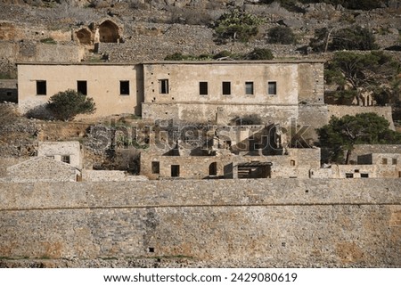 The abandoned Bastion Fortress and ruins of the famous historical landmark, Spinalonga, former Leper Colony on Kalydon, a rocky, arid Islet in the Bay of Elounda and wider area Mirabello Bay in Crete. Royalty-Free Stock Photo #2429080619