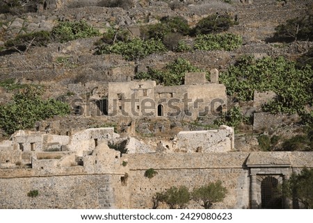 The abandoned Bastion Fortress and ruins of the famous historical landmark, Spinalonga, former Leper Colony on Kalydon, a rocky, arid Islet in the Bay of Elounda and wider area Mirabello Bay in Crete. Royalty-Free Stock Photo #2429080623