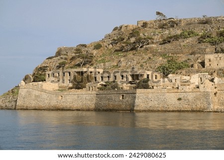 The abandoned Bastion Fortress and ruins of the famous historical landmark, Spinalonga, former Leper Colony on Kalydon, a rocky, arid Islet in the Bay of Elounda and wider area Mirabello Bay in Crete. Royalty-Free Stock Photo #2429080625