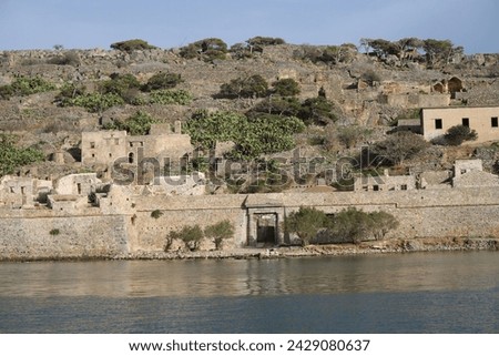 The abandoned Bastion Fortress and ruins of the famous historical landmark, Spinalonga, former Leper Colony on Kalydon, a rocky, arid Islet in the Bay of Elounda and wider area Mirabello Bay in Crete. Royalty-Free Stock Photo #2429080637