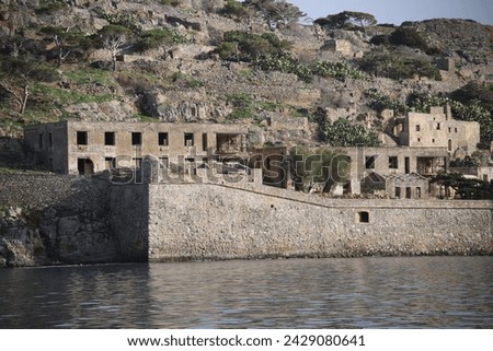 The abandoned Bastion Fortress and ruins of the famous historical landmark, Spinalonga, former Leper Colony on Kalydon, a rocky, arid Islet in the Bay of Elounda and wider area Mirabello Bay in Crete. Royalty-Free Stock Photo #2429080641