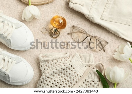 Beige female clothes and accessories on beige background, top view