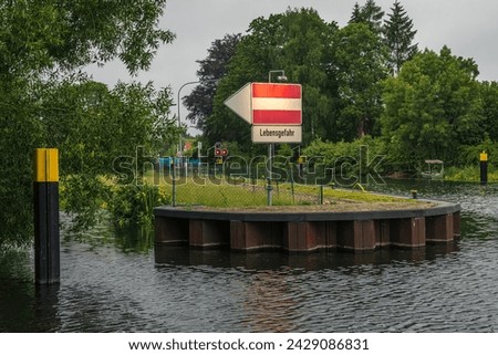 Sign: Lebensgefahr (German for - Danger to life), seen at the River Elde in Luebz, Germany Royalty-Free Stock Photo #2429086831