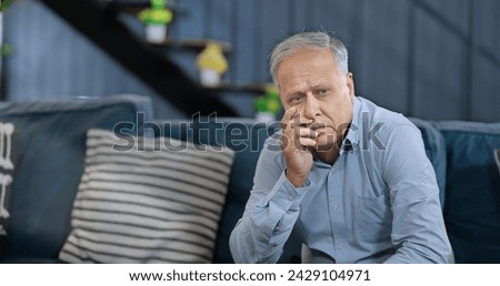 Worried retired old upset senior man sitting alone sofa feel sorrow abandoned anxiety home. Unhappy Indian middle aged male grieving think lonely depressed pensive suffer health issues problems Royalty-Free Stock Photo #2429104971