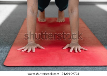 Young woman practicing yoga, doing Push ups or press ups exercise, phalankasana Plank pose, working out, wearing sportswear. Close-up of hands