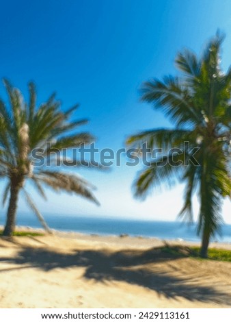 Defocused coconut trees in the sea with blue clouds