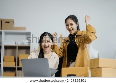 Asian business woman are excited business success with inspiration from their excellent financial results that are happy working in a modern office on a computer.