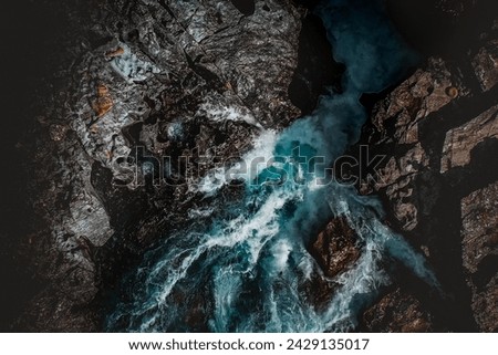 unlight sneaks through the cracks of the rugged terrain, kissing the rushing waters of a lively Scandinavian cascade. The interplay of light and shadow adds drama to the natural allure, painting a