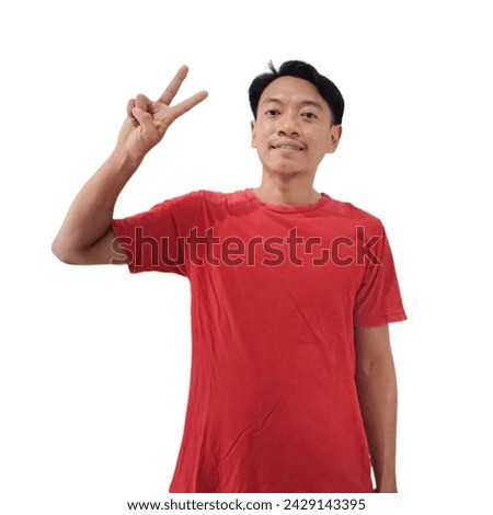 Portrait happy Asian handsome young man smiling standing wearing red t-shirt he showing fingers doing victory V sign or number two, looking to camera, studio shot isolated white background