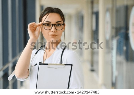 Portrait of young woman doctor with white coat standing in hospital