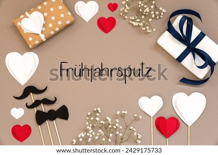 Flat Lay With German Text Fruehjahrsputz Means Spring Cleaning. Colorful Accessories Like, Gifts, Presents, Hearts, Flowers And Male Decoration Like Mustache. Flat Lay With Paper Background.