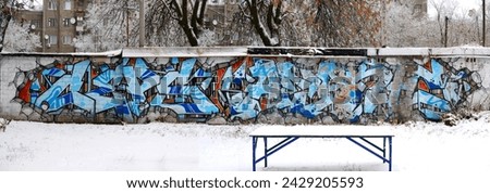 The old wall decorated with paint stains in the style of street art culture. Colorful background of full graffiti painting artwork with bright aerosol outlines on wall. Colored background texture