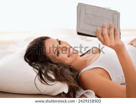 Woman, tablet and reading in bedroom, morning and story with ebook for knowledge, information or novel. Girl, person and happy to relax in bed with digital touchscreen for streaming app at apartment Royalty-Free Stock Photo #2429218503