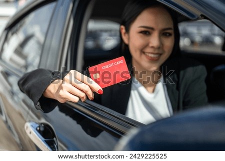 Young beautiful asian business women getting new car. Hand holding credit card payment. Car owner paying fuel pump with credit card customer mileage point loyalty reward. Driving vehicle on the road