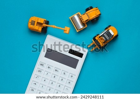 Forelift, excavator, asphalt paver and calculator on blue background