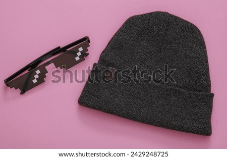 Pixelated 8 bit sunglasses with hat on pink background