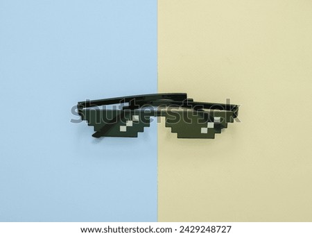 Pixelated 8 bit sunglasses on pastel background