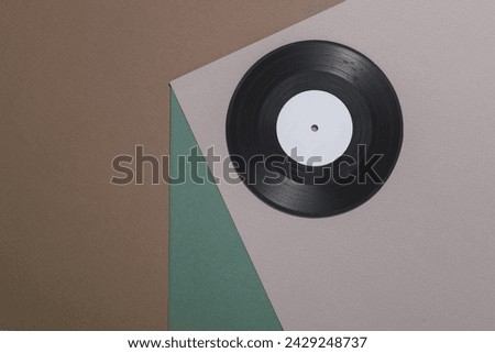 Vinyl record on a paper cube. Optical illusion. Geometric composition. Minimalistic creative layout